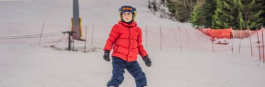 Banner, dağlarda kayak yapan eski bir çocuk. Güvenlik kaskı, gözlüğü ve direkleri olan aktif bir çocuk. Küçük çocuklar için kayak yarışı. Aile için kış sporu. Alp okulunda çocuklar kayak dersi alıyor. Küçük