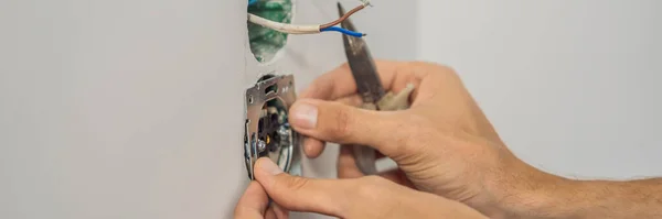 Master elektriker installerar ett uttag i huset BANNER, LONG FORMAT — Stockfoto