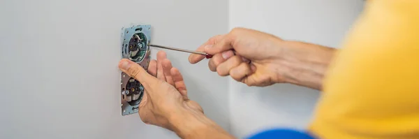 Master elektriker installerar ett uttag i huset BANNER, LONG FORMAT — Stockfoto