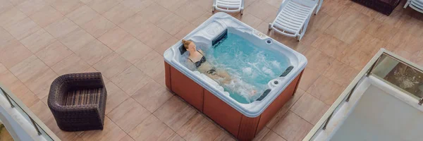 Banner, lang uitzicht op de Drone. Portret van jonge zorgeloze vrolijke lachende vrouw ontspannen in hot tub tijdens het genieten van gelukkig reizen moment vakantie leven tegen de achtergrond van groene grote bergen — Stockfoto