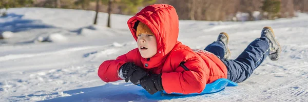 BANNER, LANG FORMAT Glücklicher und positiver kleiner Junge genießt Rodeln und Kälte im Freien, Winterspaß-Aktivitätskonzept — Stockfoto
