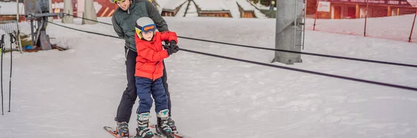 प्रशिक्षक मुलाला स्की लिफ्ट बॅनर, लाँग फॉर्मॅटवर वापरण्यास शिकवते — स्टॉक फोटो, इमेज