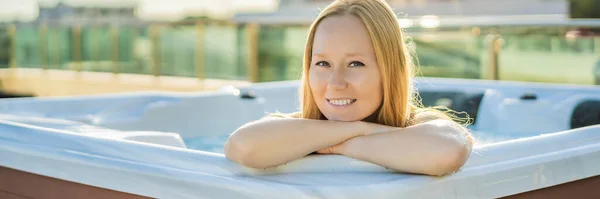 BANNER, FORMATO LARGO Retrato de la joven despreocupada feliz mujer sonriente relajándose en la bañera de hidromasaje durante el disfrute de la vida feliz momento de viaje de vacaciones en el fondo de grandes montañas verdes —  Fotos de Stock