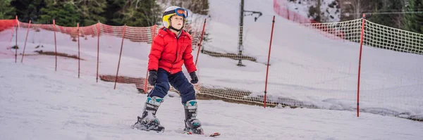 BANNER, LONG FORMAT Ski pour enfants en montagne. Enfant tout-petit actif avec casque de sécurité, lunettes et bâtons. Course de ski pour jeunes enfants. Sport d'hiver pour la famille. Cours de ski pour enfants à l'école de ski alpin. Peu — Photo