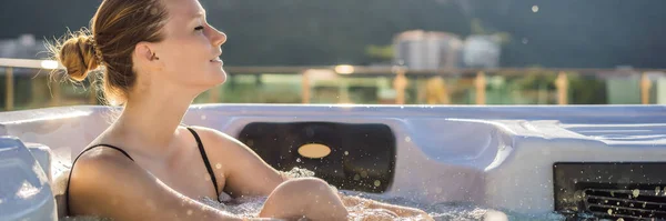 BANNER, FORMATO LARGO Retrato de la joven despreocupada feliz mujer sonriente relajándose en la bañera de hidromasaje durante el disfrute de la vida feliz momento de viaje de vacaciones en el fondo de grandes montañas verdes — Foto de Stock
