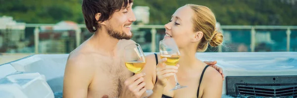 BANNER, FORMATO LARGO Retrato de la joven y despreocupada feliz pareja sonriente relajarse en la bañera de hidromasaje durante el disfrute de la vida feliz momento de viaje de vacaciones en el fondo de grandes montañas verdes — Foto de Stock