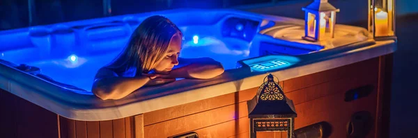 BANNER, FORMATO LARGO Retrato de una joven feliz y despreocupada mujer sonriente que se relaja en la bañera de hidromasaje por la noche mientras disfruta de unas felices vacaciones en un momento de viaje. La vida en el fondo de grandes montañas verdes —  Fotos de Stock