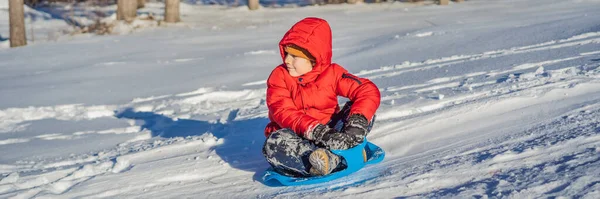 Menino pequeno feliz e positivo apreciando trenó e tempo frio ao ar livre, conceito de atividade divertida de inverno BANNER, LONG FORMAT — Fotografia de Stock