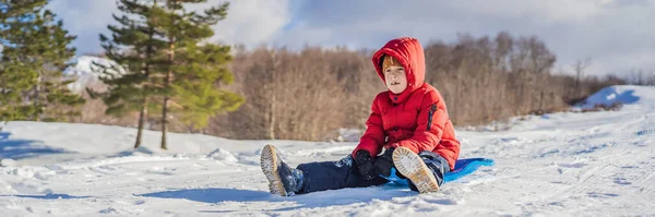 BANNER, DLOUHÁ FORMÁT šťastný a pozitivní malý chlapec těší sáňkování a chladné počasí venku, zimní zábava koncept — Stock fotografie