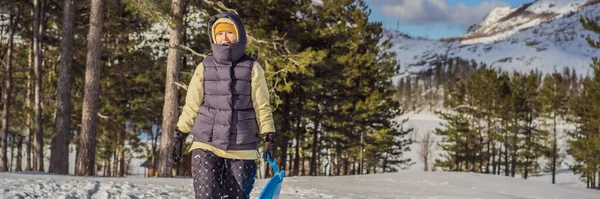 BANNER, LONG FORMAT Glad kvinna som roar sig under rullning nerför bergssluttningen på släde. Vintersport med snö. Folk åker släde — Stockfoto