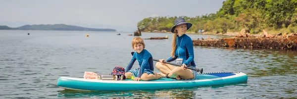 母亲和儿子，两个快乐的家庭，在暑假期间喜欢站起来划桨 — 图库照片