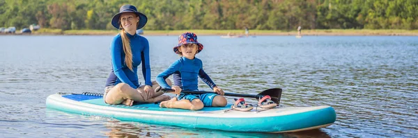 Lycklig familj på två, mor och son, njuter av stand up paddling under sommarsemester BANNER, LONG FORMAT — Stockfoto