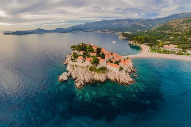 Havacılık bilimi. Uçan İHA 'nın görüntüsü. Karadağ 'ın güzel bir yaz gününde Budva' daki Sveti Stefan adasının panoramik manzarası. Üst Manzara. Güzel yerler.