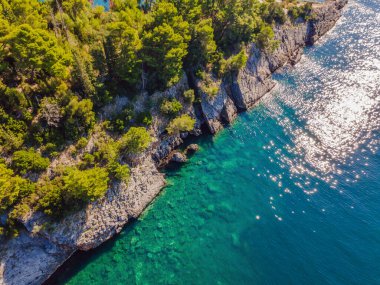 Karadağ 'ın Adriyatik kıyıları. Turkuaz Mediteran denizi ve yeşil kozalaklı ağaçlarıyla kayalık kıyı. Harika bir yaz manzarası. İHA