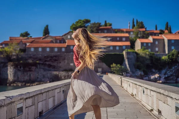 Mulher turista no fundo da bela vista da ilha de Santo Estêvão, Sveti Stefan no Budva Riviera, Budva, Montenegro. Viajar para Montenegro conceito — Fotografia de Stock