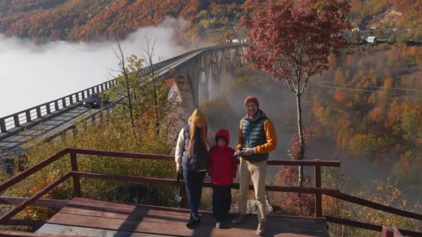 Rodina turistů navštíví nádherný most Djurdjevica přes kaňon řeky Tara v severní části Černé Hory. Zastřelen v podzimní sezóně. Koncept cestování do východní Evropy — Stock video