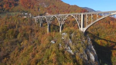 Karadağ 'ın kuzey kesimindeki Tara nehri kanyonu üzerindeki muhteşem Curdjevica Köprüsü' nün hava videosu. Sonbahar sezonunda çekilmiş. Doğu Avrupa konseptine seyahat