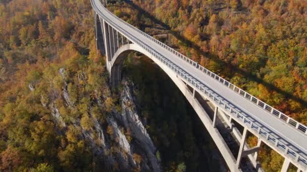 Vídeo aéreo da magnífica Ponte Djurdjevica sobre o desfiladeiro do rio Tara, na parte norte de Montenegro. Foi baleado na época do Outono. Viajar para a Europa Oriental conceito — Vídeo de Stock