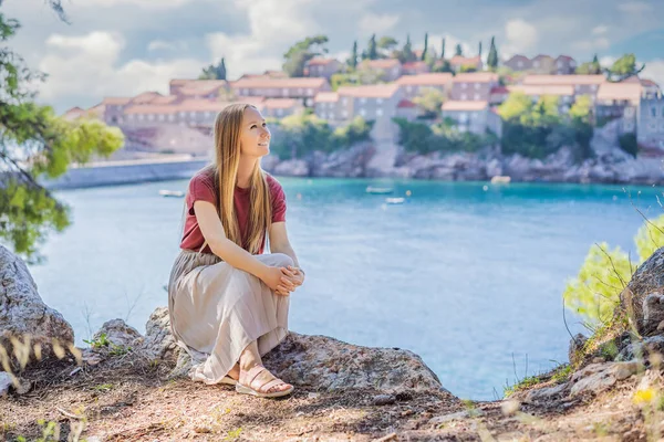 Mulher turista no fundo da bela vista da ilha de Santo Estêvão, Sveti Stefan no Budva Riviera, Budva, Montenegro. Viajar para Montenegro conceito — Fotografia de Stock