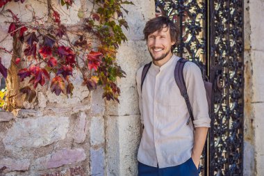 Karadağ 'ın Budva Riviera kentindeki St. Stephen adasının güzel manzarasının arka planındaki erkek turist Sveti Stefan. Karadağ 'a Seyahat