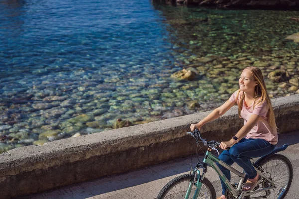 Bisikletli kadın turist Karadağ 'da Budva' yı keşfediyor. Karadağ 'da bisiklet kavramı — Stok fotoğraf