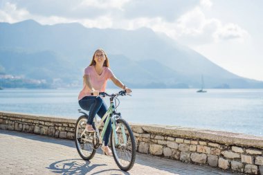 Bisikletli kadın turist Karadağ 'da Budva' yı keşfediyor. Karadağ 'da bisiklet kavramı