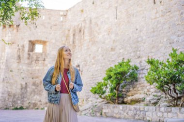 Budva 'nın eski kasabasında genç bir kadın turist. Karadağ 'a Seyahat