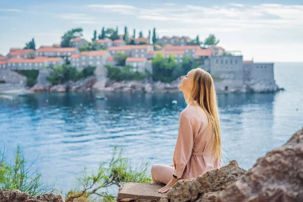 Mulher turista no fundo da bela vista da ilha de Santo Estêvão, Sveti Stefan no Budva Riviera, Budva, Montenegro. Viajar para Montenegro conceito — Fotografia de Stock
