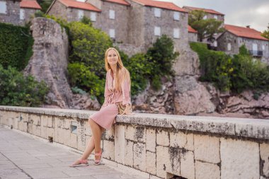 Karadağ 'ın Budva Riviera kentindeki St. Stephen adasının güzel manzaralı kadın turist Sveti Stefan. Karadağ 'a Seyahat