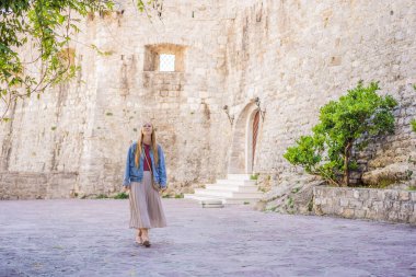 Budva 'nın eski kasabasında genç bir kadın turist. Karadağ 'a Seyahat
