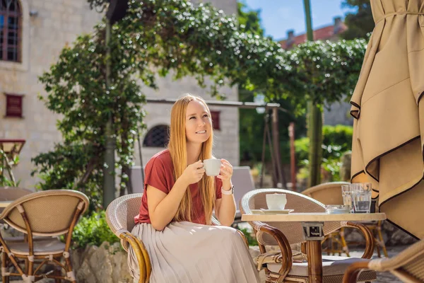 Ung kvinna turist dricker cofee i gamla stan i Budva. Resor till Montenegro konceptet — Stockfoto