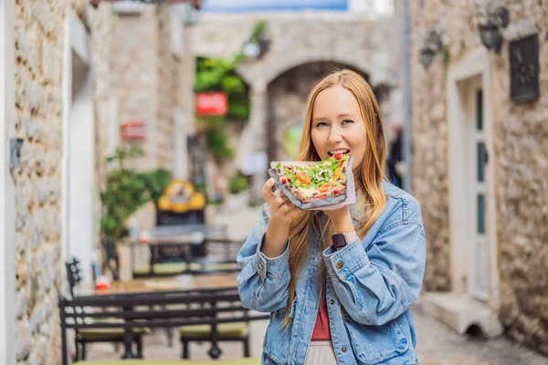Молода жінка купує традиційну піцу в старому місті Будува. Подорож до Чорногорії — стокове фото