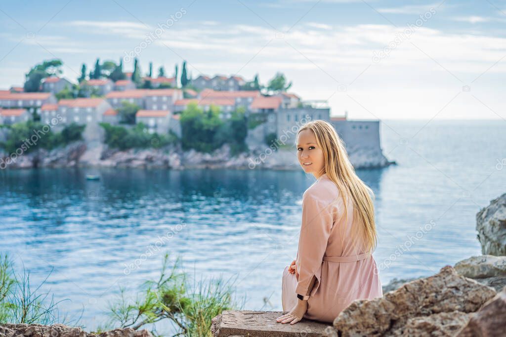 Woman tourist on background of beautiful view of the island of St. Stephen, Sveti Stefan on the Budva Riviera, Budva, Montenegro. Travel to Montenegro concept
