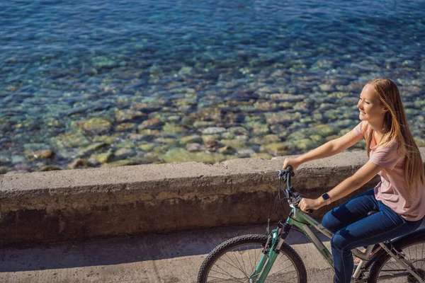 Bisikletli kadın turist Karadağ 'da Budva' yı keşfediyor. Karadağ 'da bisiklet kavramı — Stok fotoğraf