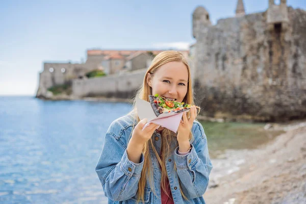 Young woman tourist eating traditional pizza in the old town of Budva. Travel to Montenegro concept — Stock Photo, Image