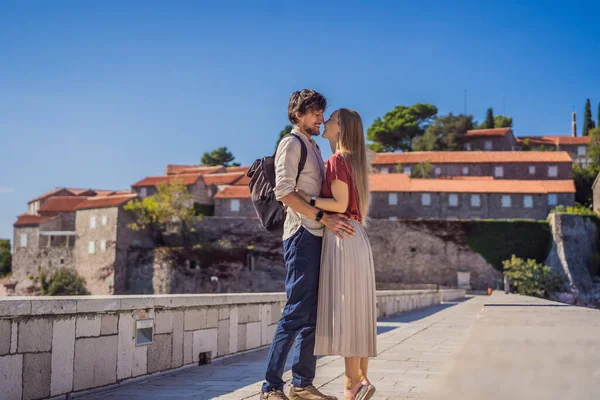 Man en vrouw toeristen op de achtergrond van een prachtig uitzicht op het eiland St. Stephen, Sveti Stefan aan de Budva Riviera, Budva, Montenegro. Reizen naar Montenegro — Stockfoto