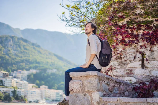 Man turist på bakgrund av vacker utsikt över ön St Stephen, Sveti Stefan på Budva Riviera, Budva, Montenegro. Resor till Montenegro konceptet — Stockfoto