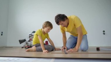 Baba ve küçük oğlu dairelerinde yere kaplama döşemişler. DIY kavramı