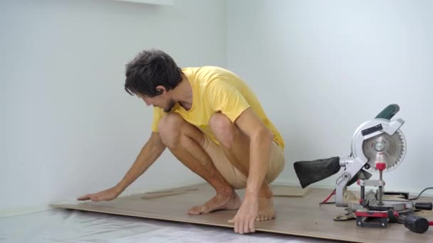 一个男人在他们公寓的地板上安装了层压板。DIY概念 — 图库视频影像