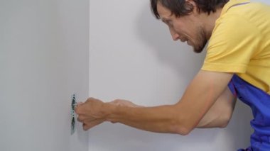 Bir elektrikçi duvara elektrik prizi takıyor. İnşaat ve ev onarımı
