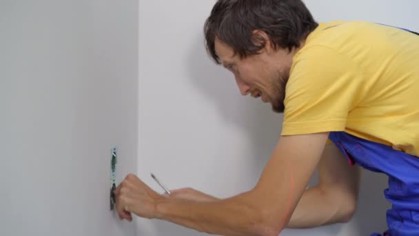 Ein Elektriker installiert eine Steckdose in die Wand. Bau und Reparatur von Häusern — Stockvideo