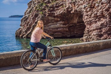 Bisikletli kadın turist Karadağ 'da Budva' yı keşfediyor. Karadağ 'da bisiklet kavramı