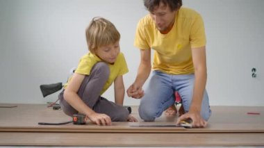 Baba ve küçük oğlu dairelerinde yere kaplama döşemişler. DIY kavramı