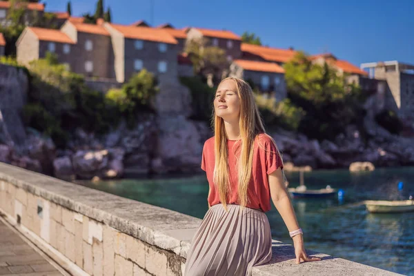 Жіночий турист на задньому плані красивого краєвиду острова Светі Стефан на Будва-Рів'єра, Бадува, Чорногорія. Подорож до Чорногорії — стокове фото