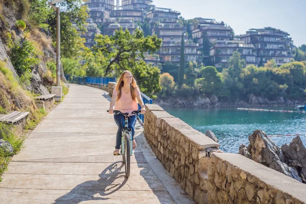 自転車での女性観光客はモンテネグロのブドヴァを探索します。モンテネグロでのサイクリングのコンセプト — ストック写真
