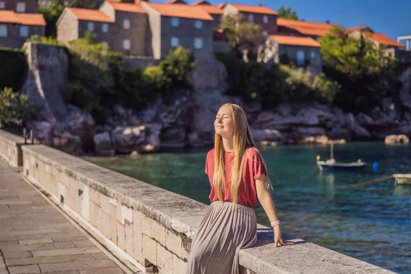 Mulher turista no fundo da bela vista da ilha de Santo Estêvão, Sveti Stefan no Budva Riviera, Budva, Montenegro. Viajar para Montenegro conceito — Fotografia de Stock
