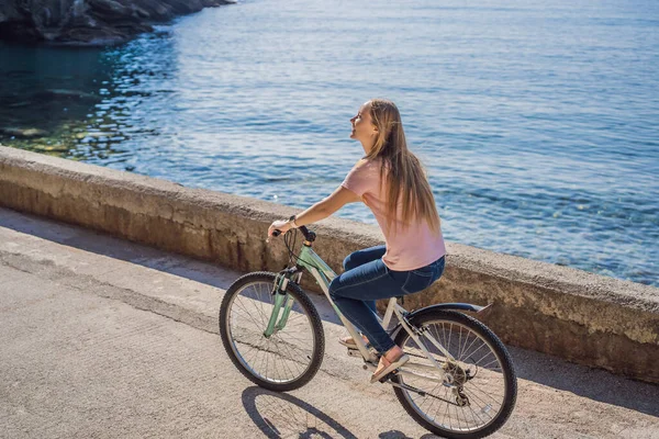 Vrouw toerist op een fiets verkent Budva in Montenegro. Fietsen in Montenegro concept — Stockfoto