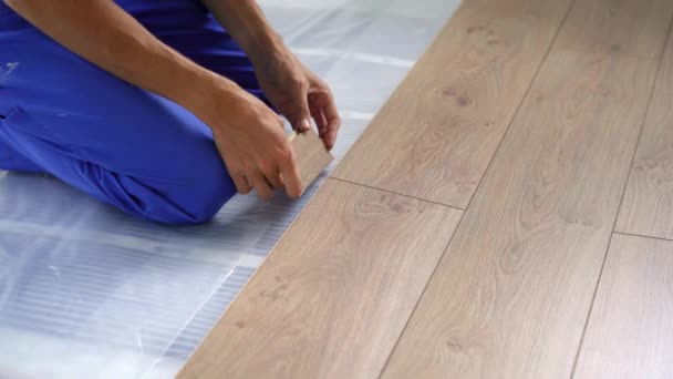 A man professional laminate installer laying laminate wood — Stock Video