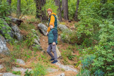 Baba ve oğul gezginler Kotor 'un manzarasından hoşlanırlar. Karadağ. Kotor Körfezi, Kotor Körfezi, Boka Kotorska ve eski şehrin duvarları. Çocuklarla Karadağ 'a seyahat etmek. Kotor 'un tahkimatları devrede