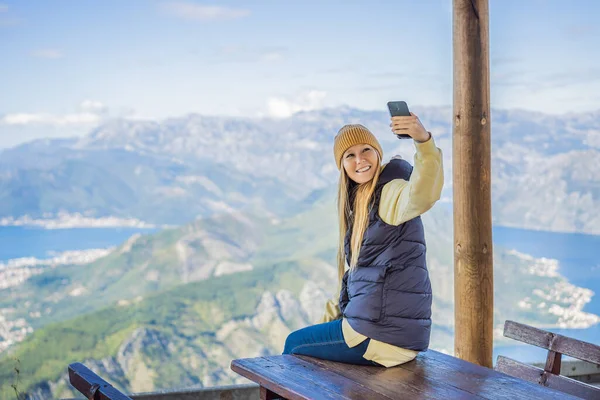 Woman tourist enjoys the view of Kotor. Montenegro. Bay of Kotor, Gulf of Kotor, Boka Kotorska and walled old city. Travel to Montenegro concept. Fortifications of Kotor is on UNESCO World Heritage — ストック写真